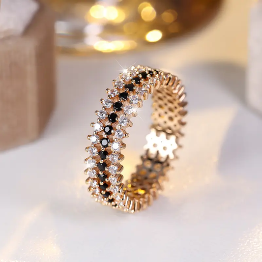 Goldring mit funkelnden weißen und schwarzen Kristallen